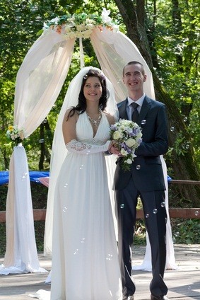 newlyweds at wedding arch