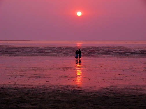 couple watching a romantic sunset over water