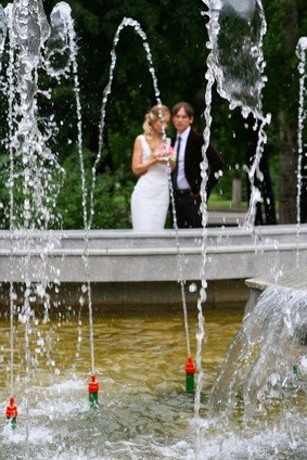 groom bride by fountain