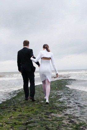 bride and groom by ocean
