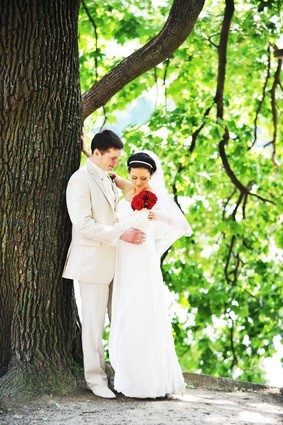 bride and groom against tree