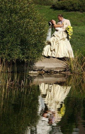 bride and groom by pond